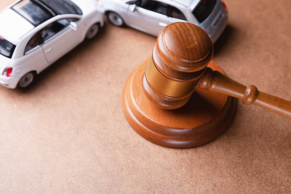 The model of the car and gavel represents an accident lawsuit or insurance court case.







