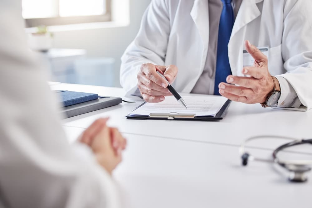  doctor and patient with consultation in clipboard for medical history, 