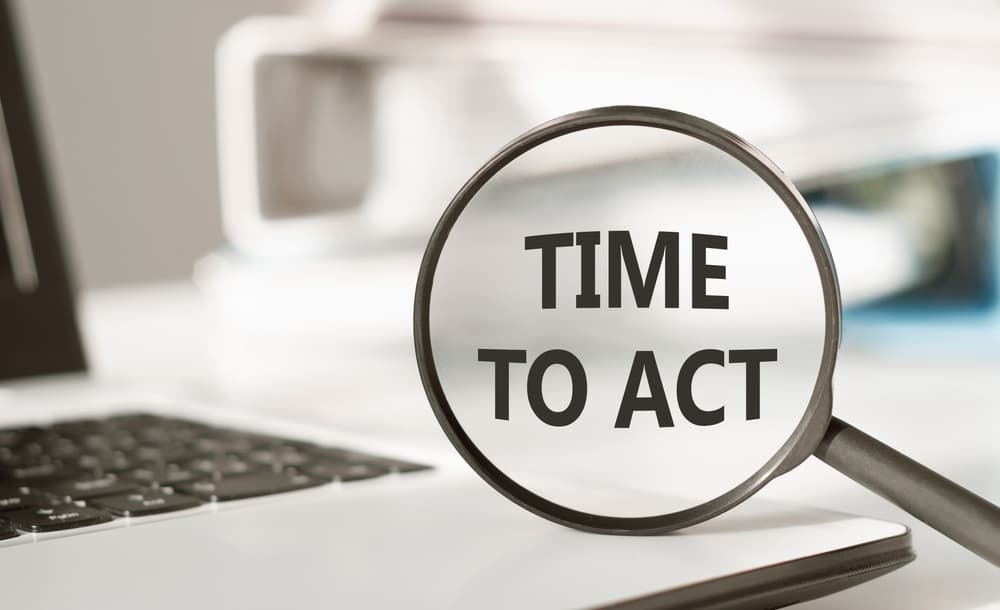 Time To Act. Text inside the magnifier on office background
