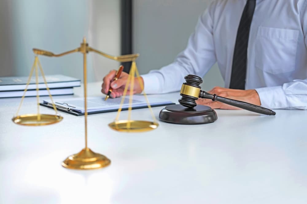 A lawyer is focused on reviewing documents, with a judge's gavel prominently displayed nearby.