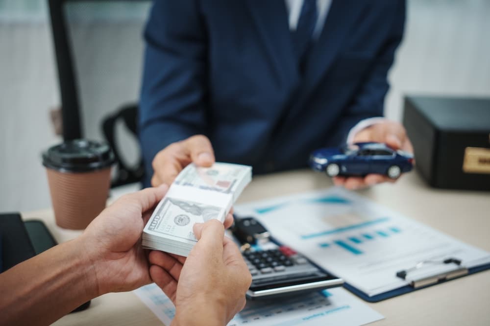 A businessman holds the key to success in car finance, concentrating on sales, insurance, and investments while effectively managing contracts and agreements in a dynamic environment.






