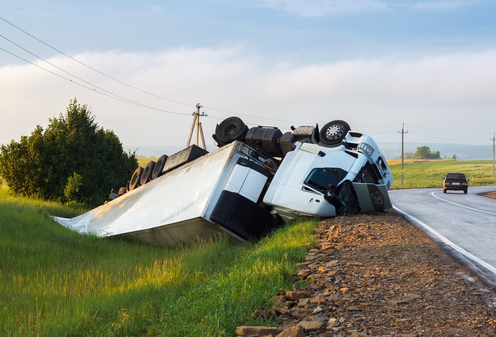 The truck is positioned in a ditch following the road accident.






