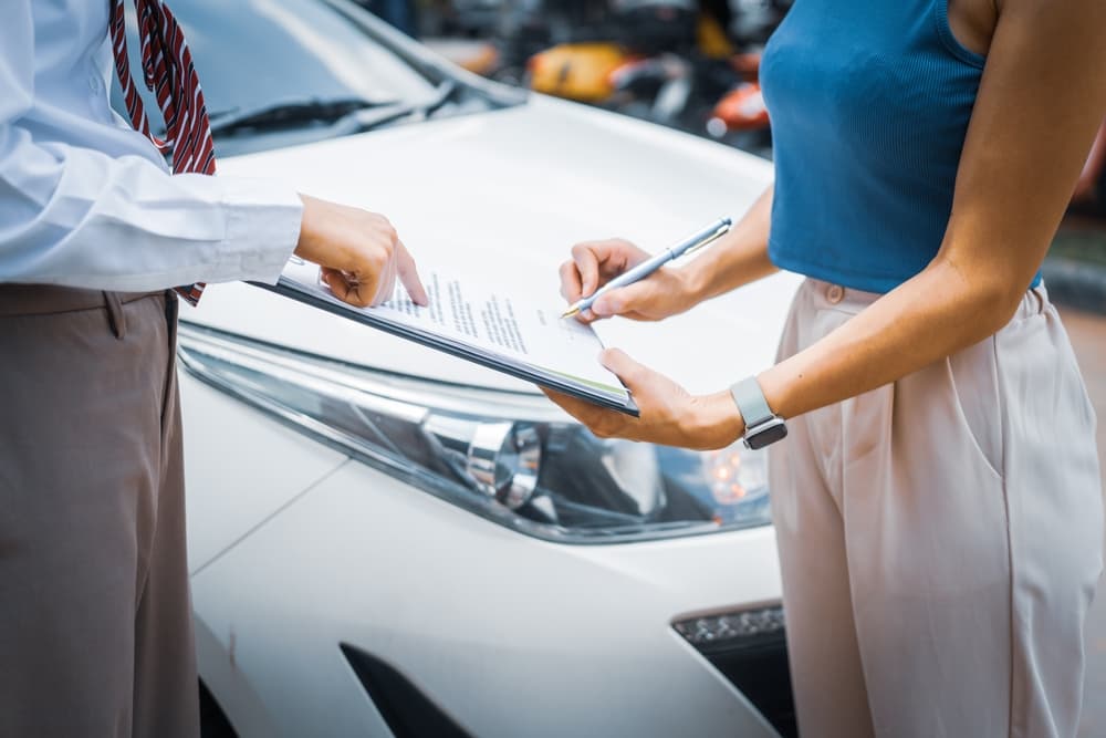 A young businesswoman is exploring her car insurance options at her desk, weighing factors like premiums, deductibles, and coverage to make an informed decision.