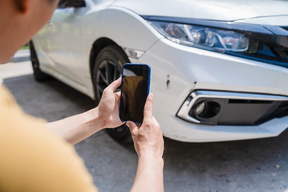 Person taking photo of a car from mobile after the accident