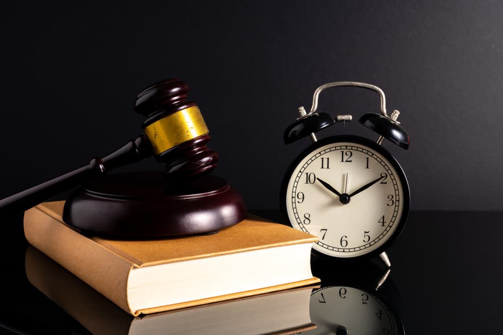 Gavel placed on a book and clock beside